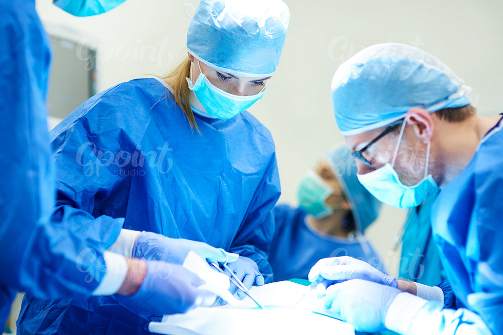 Female doctor using medical scissors over surgery