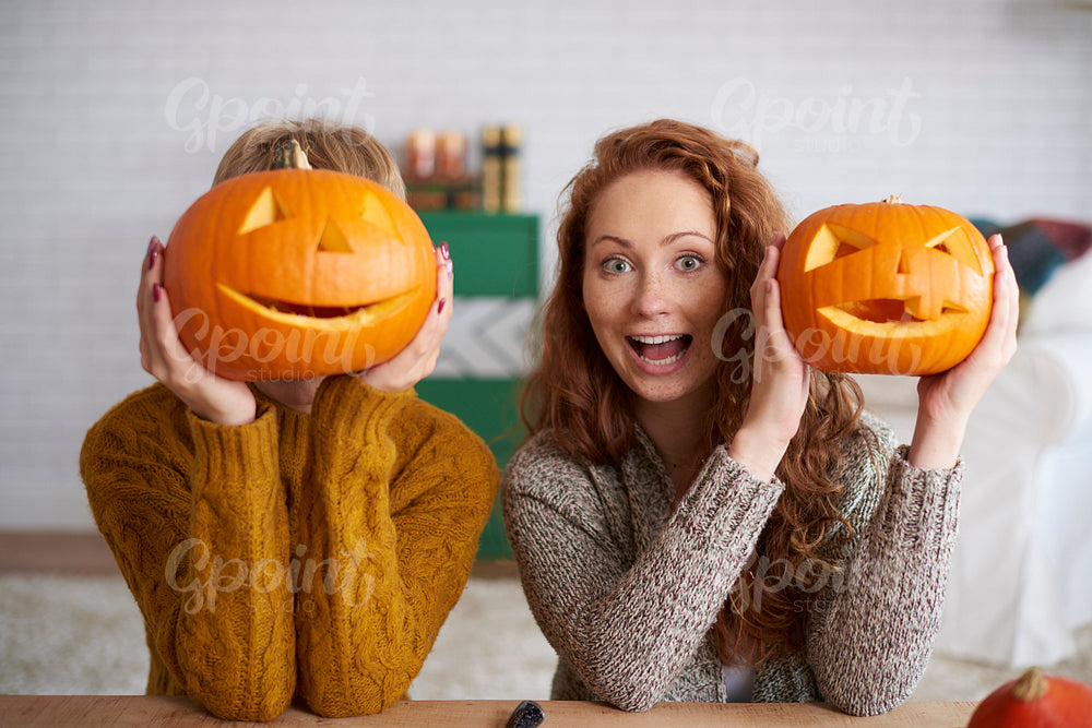 Shouting women showing halloween pumpkins