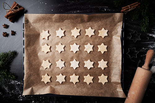 Top view of baking tray with raw star shaped cookies