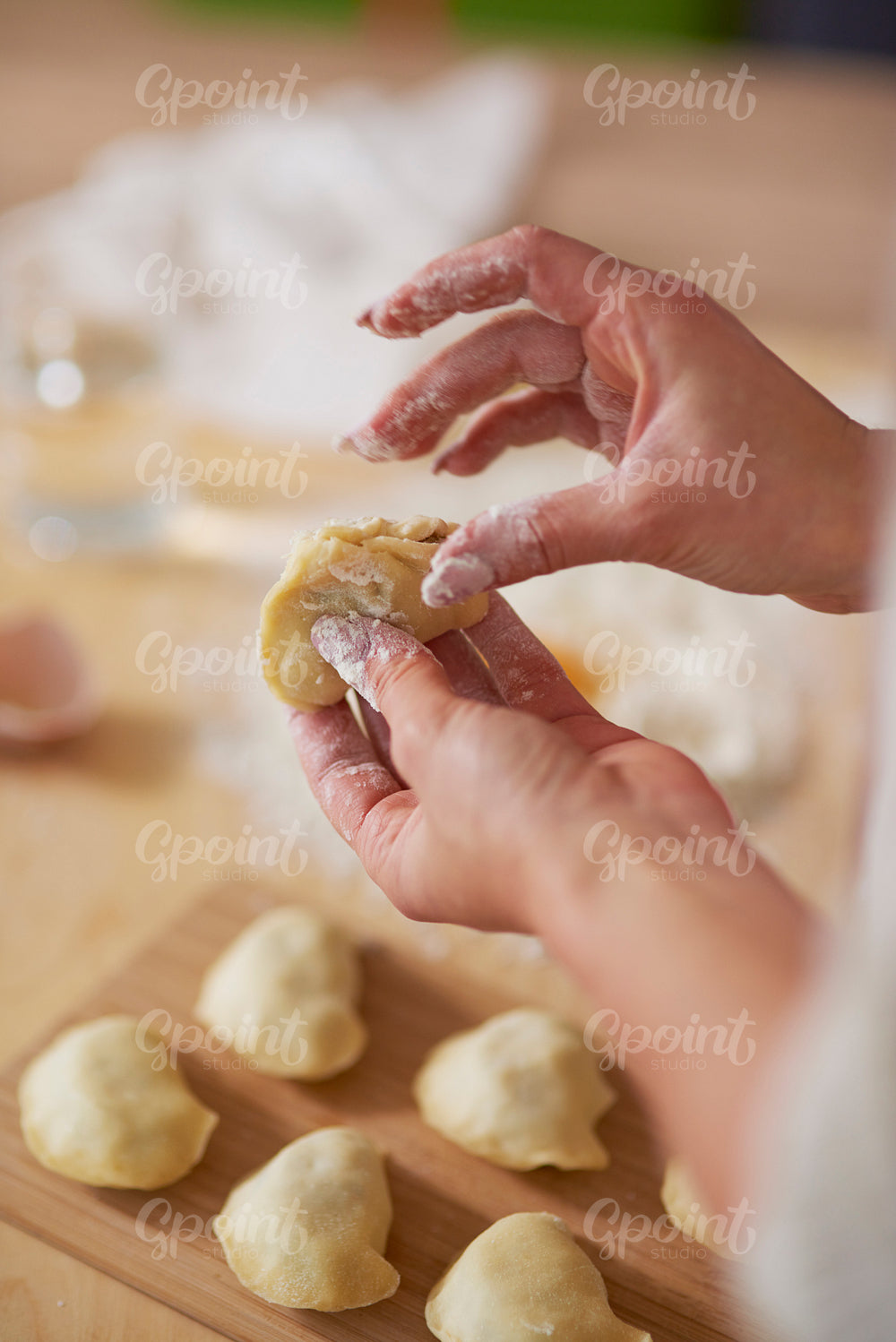 Woman closing dumpling with traditional filling