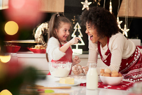 Mother and daughter enjoying in the kitchen at Christmas