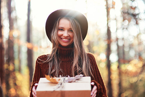 Portrait of autumnal woman with wrapped gift