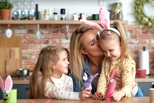 Cute kissing mom with her daughters during Easter fun