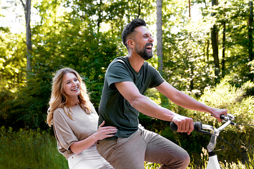 Happy couple having fun on a bike in nature