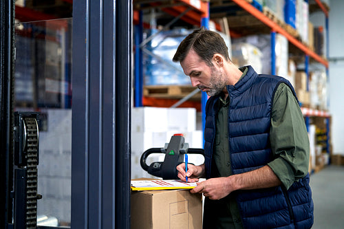 Caucasian man packing boxes in warehouse
