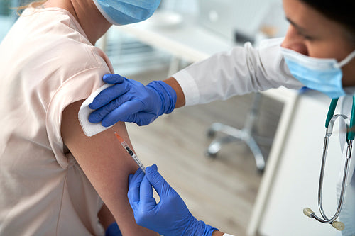 Close up of woman being vaccinated in a doctor's office