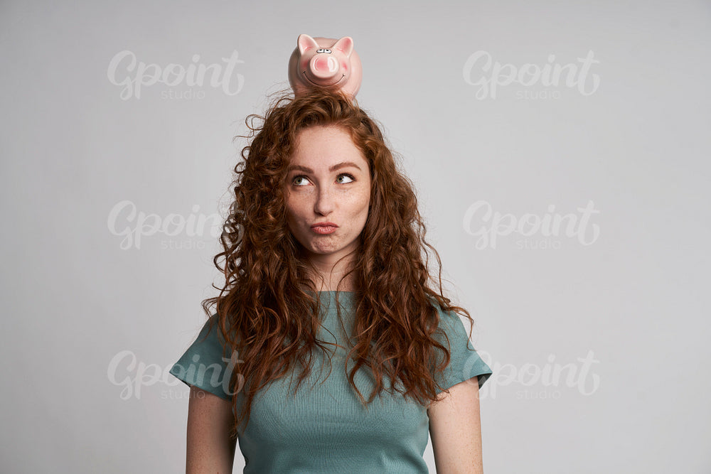 Funny woman with piggy bank on the head 
