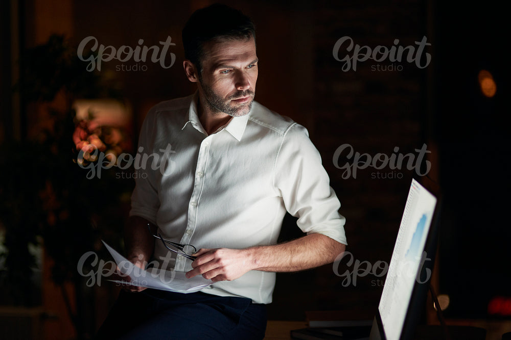 Serious man analyzing document in his office