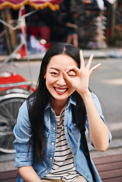 Portrait of happy woman showing ok sign