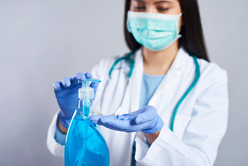 Female doctor using a hand sanitizer