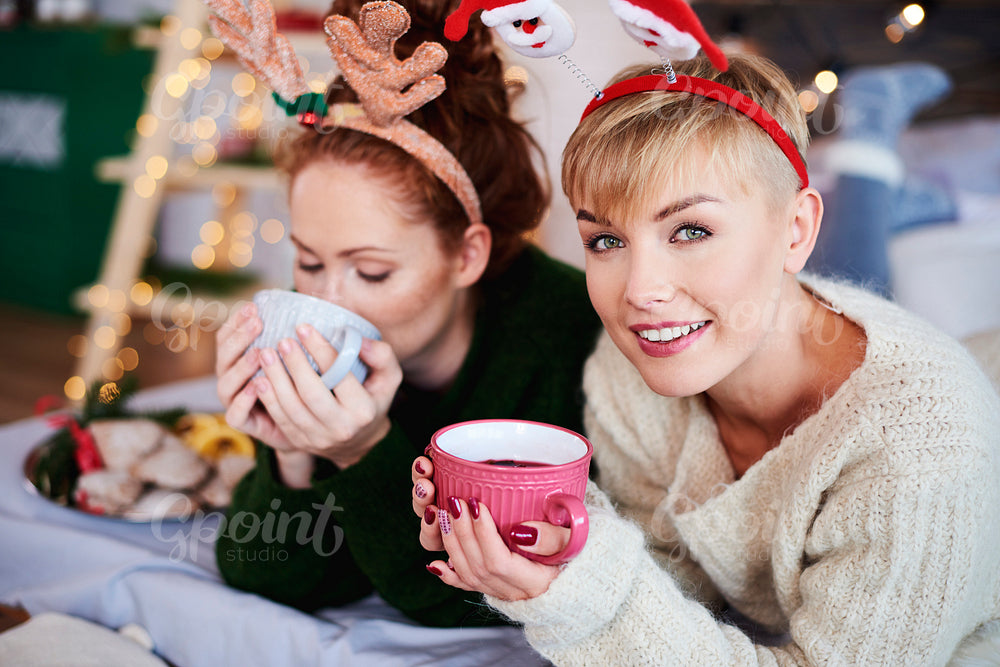 Two girls drinking hot tea or mulled wine