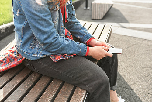 Side view of young woman with mobile phone