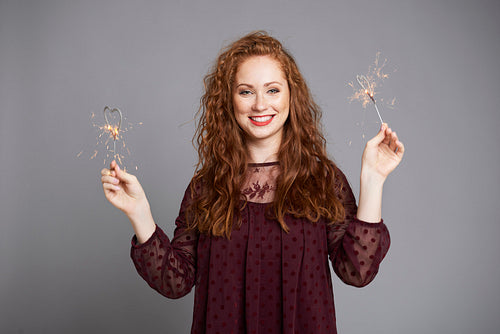 Smiling woman having fun with sparklers