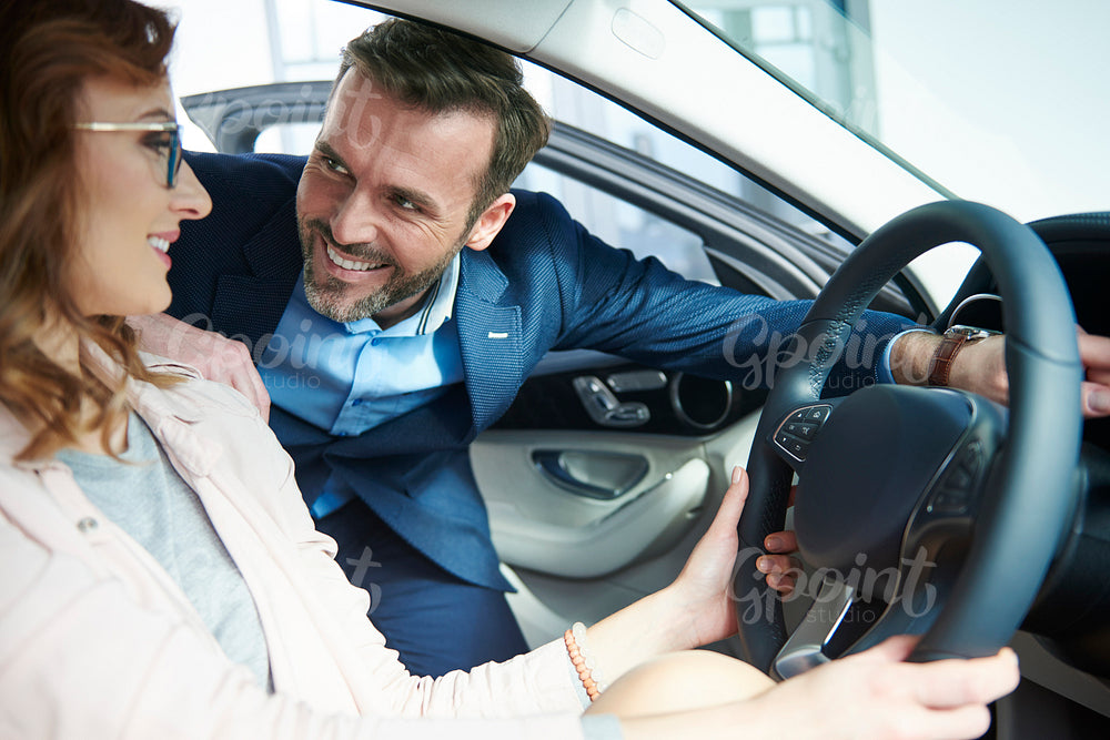 Couple checking out new car interior