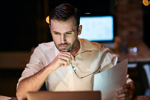 Focused man working late in his home office