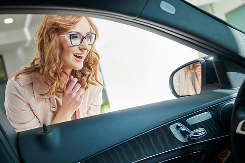 Waist up of excited woman buying car