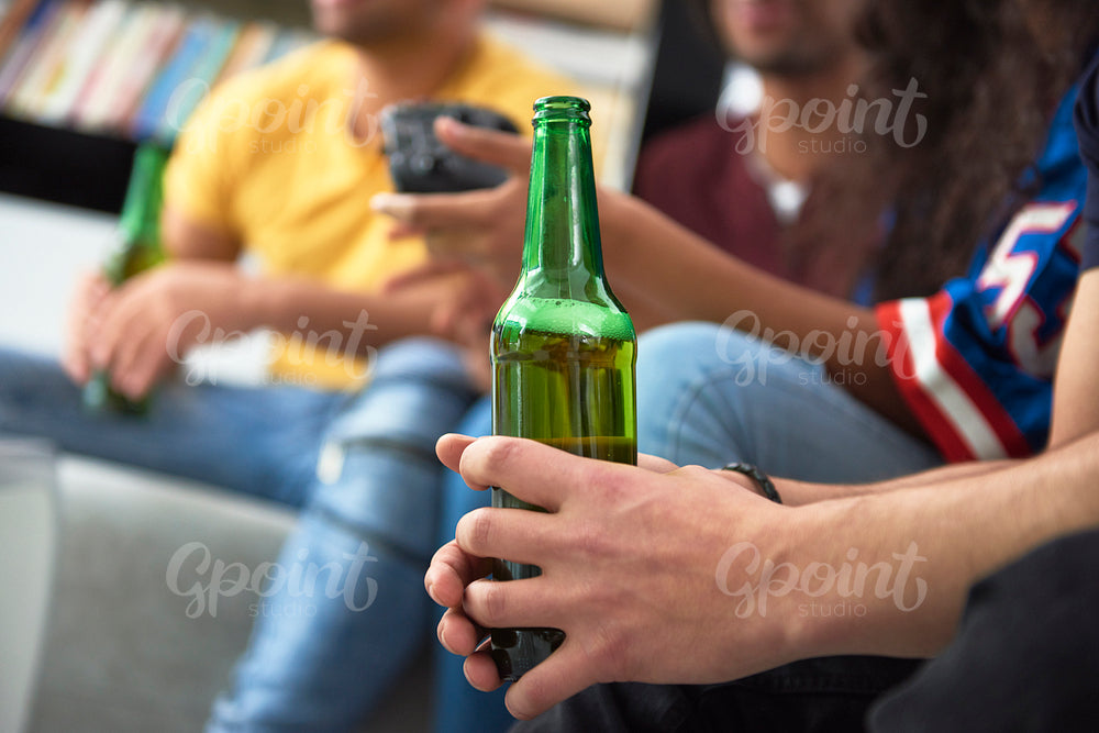Close up of group of friends with a beer bottle