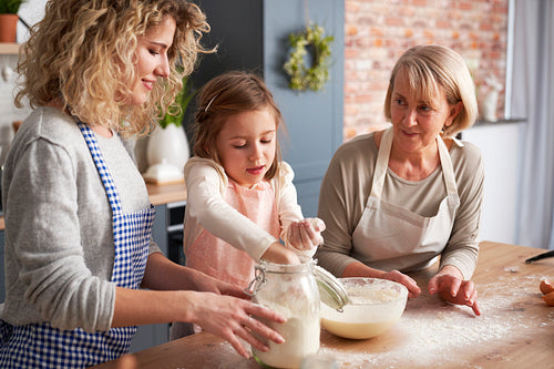 Girl helping mother and grandma during Easter baking