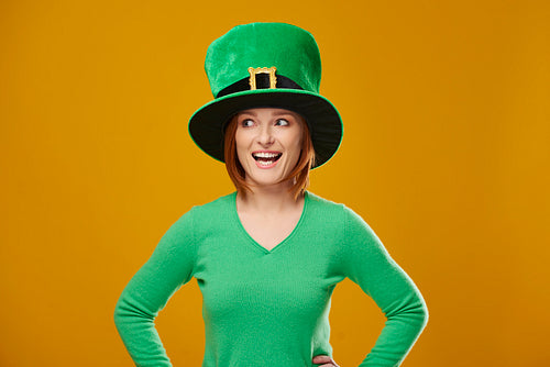 Screaming woman with leprechaun's hat looking at copy space