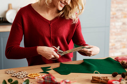 Happy woman cutting out Christmas decorations