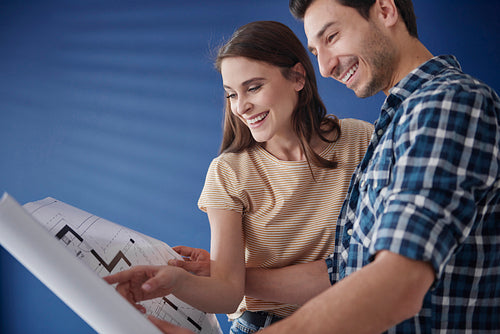 Young couple browsing blueprint in new house