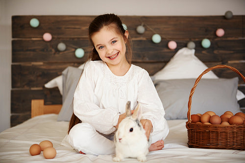 Portrait of girl with rabbit and easter basket of eggs