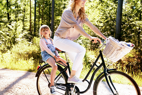 Mother and daughter riding bike in the woods