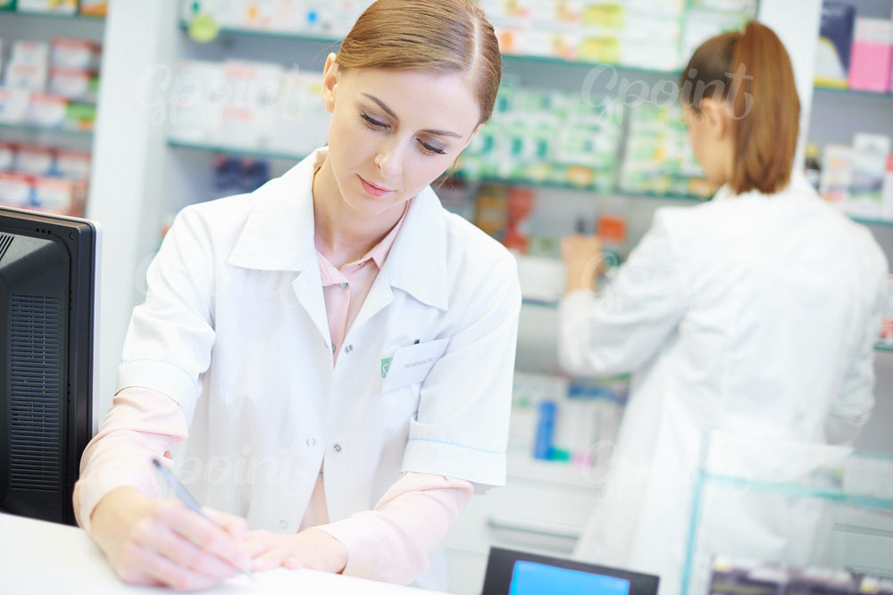 Close up of two busy female pharmacists