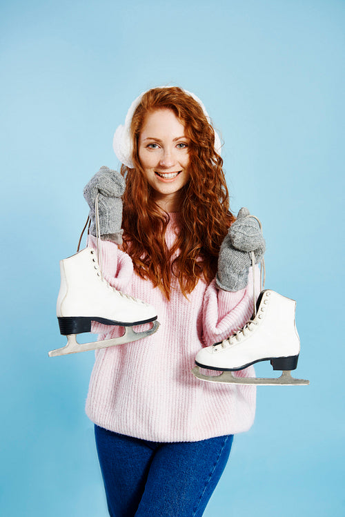 Portrait of happy girl holding ice skates