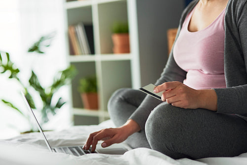 Close up image of pregnant woman doing shopping online