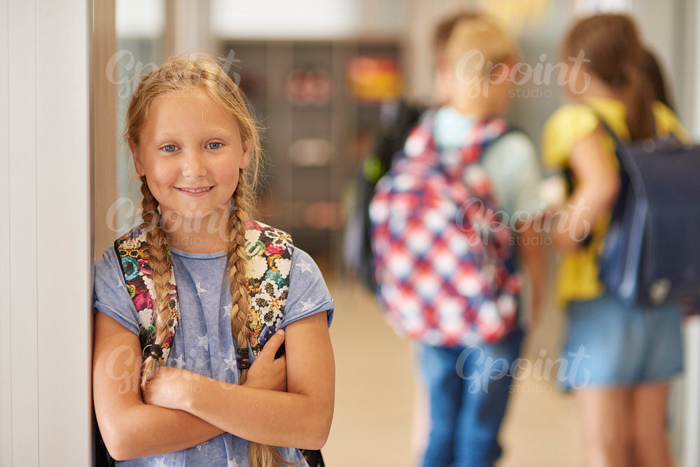 Portrait of girl with rucksack at school corridor