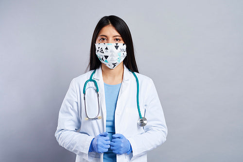 Mid shot portrait of Asian female doctor in face mask
