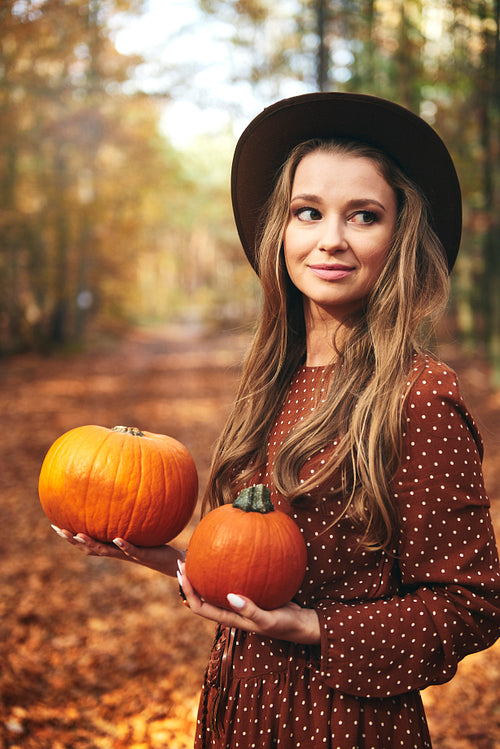 Beautiful woman holding some pumpkins