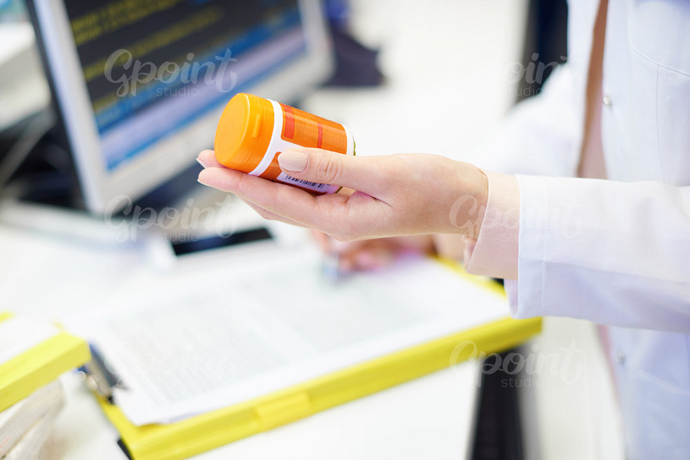 Pharmacist holding pill bottle