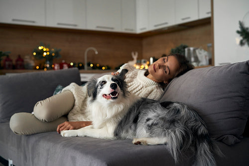Woman with dog chilling at the sofa during the Christmas