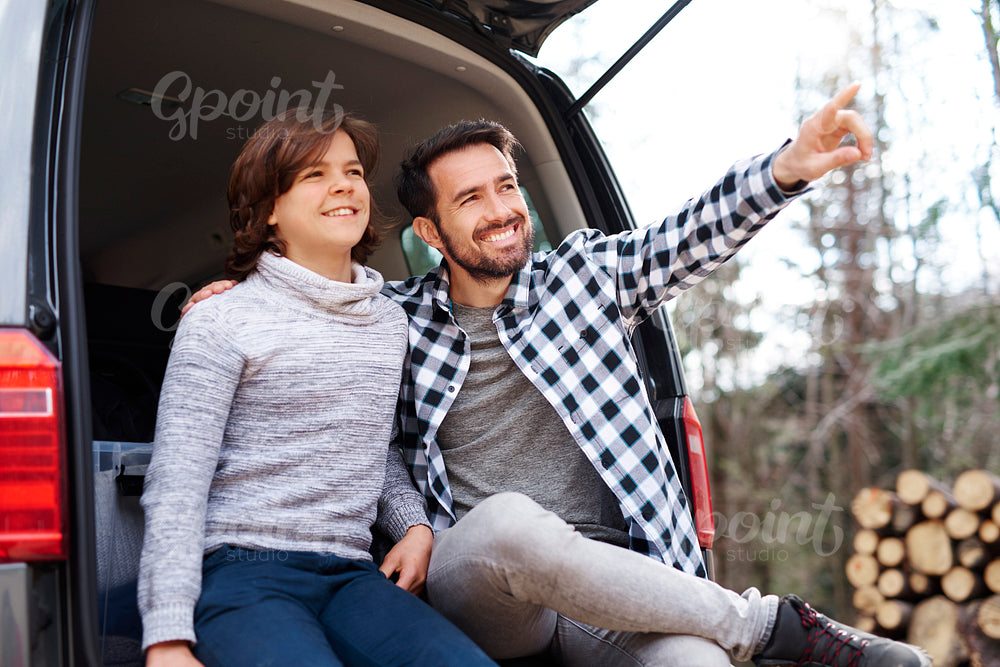 Happy father and son traveling by car