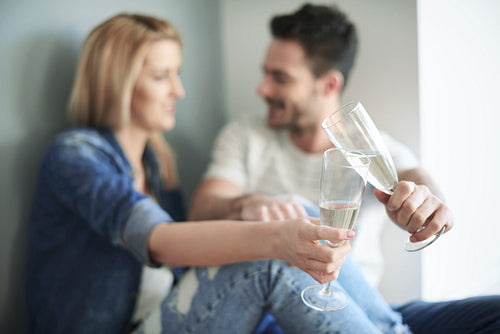 Loving couple toasting new home with champagne