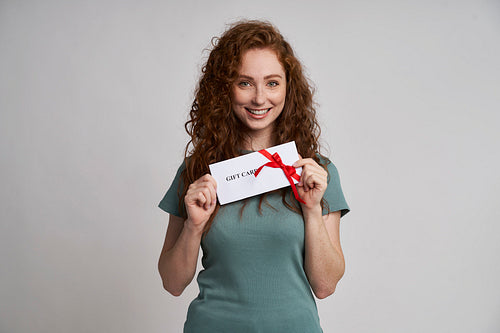 Happy woman holding gift card