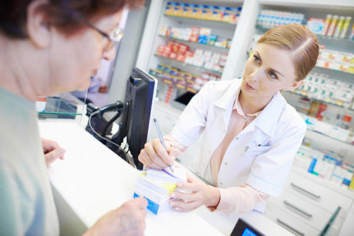 Pharmacist talking to customer about prescription