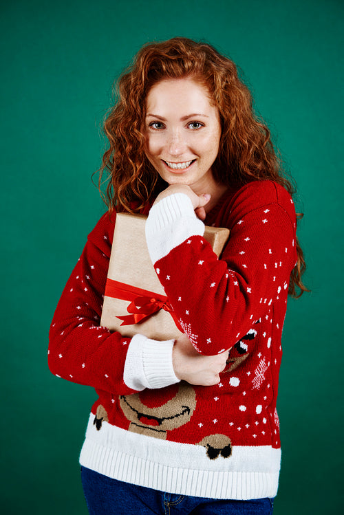 Cheerful girl embracing christmas present