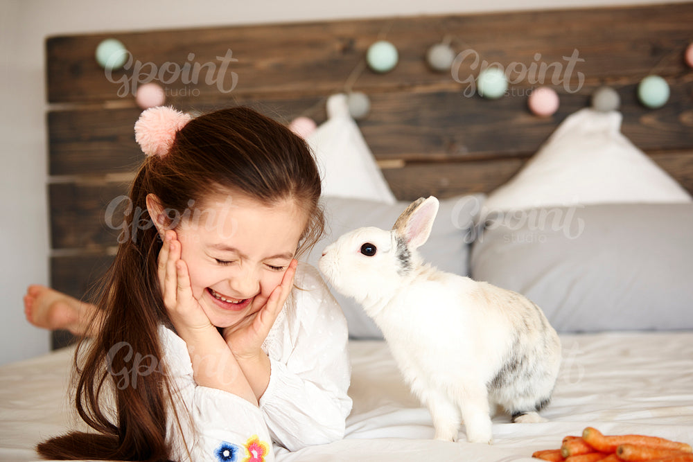 Shot of rabbit kissing happy girl
