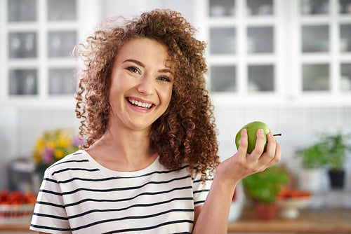 Portrait of smiling young woman holding an apple