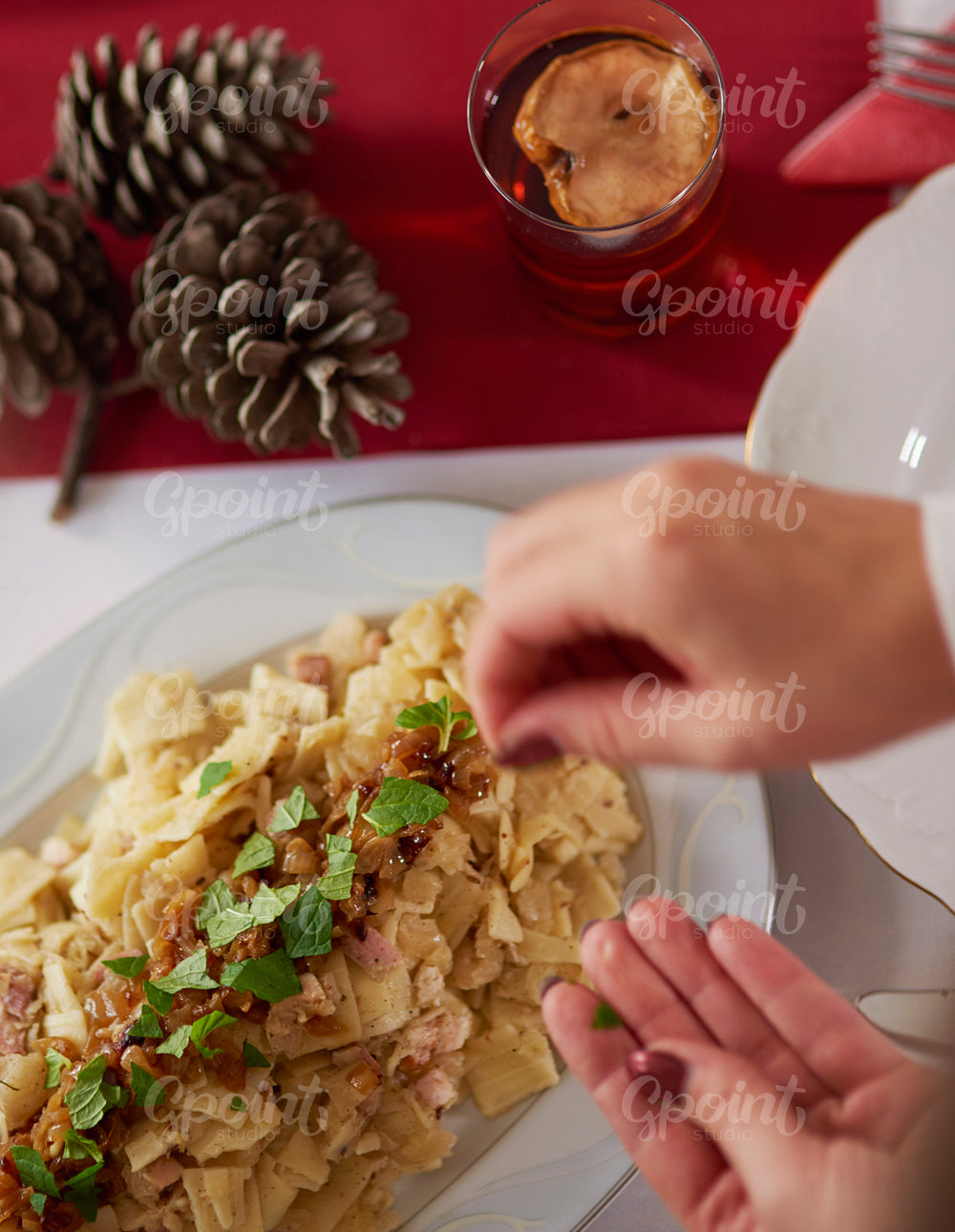 Decorating fettuccini with piece of herbs