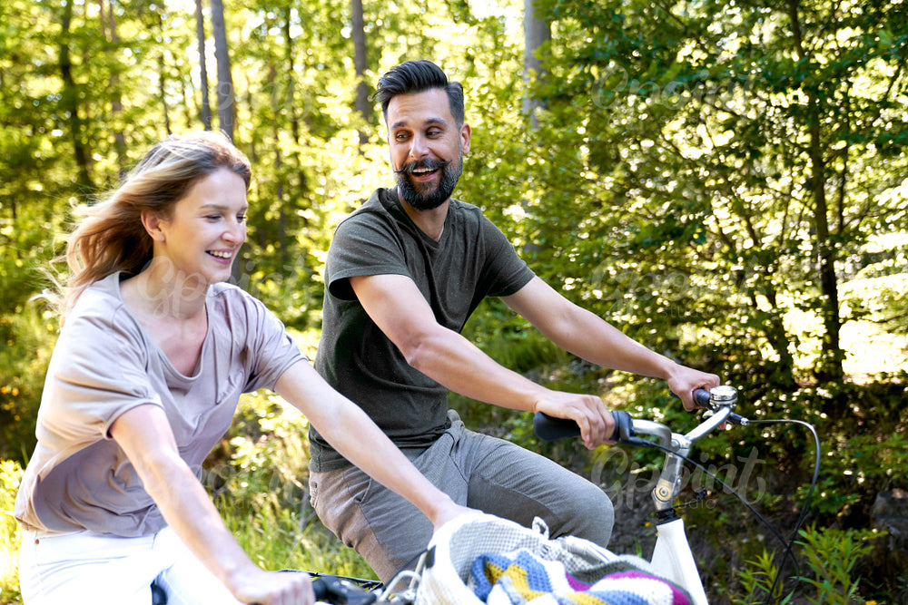 Close up of couple riding bikes in nature