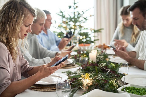 Family of caucasian people spending Christmas Eve with mobile phones
