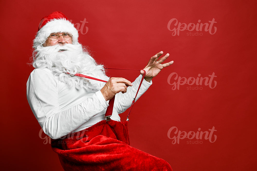 Funny caucasian Santa Claus with red suspenders 