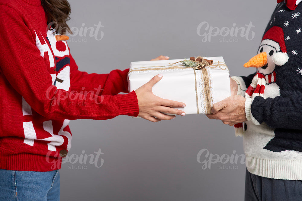 Close up of couple holding Christmas gift