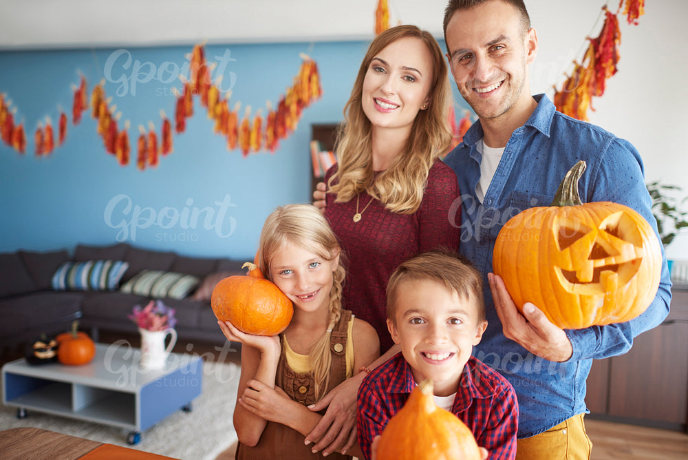 Happy family holding Halloween pumpkins