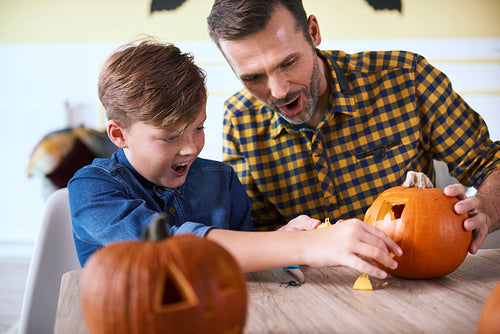 Father and son carving pumpkin