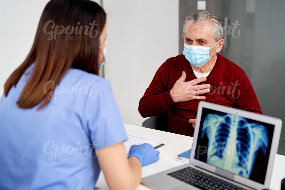 Female doctor analyzing the patient's lung X-rays during visit